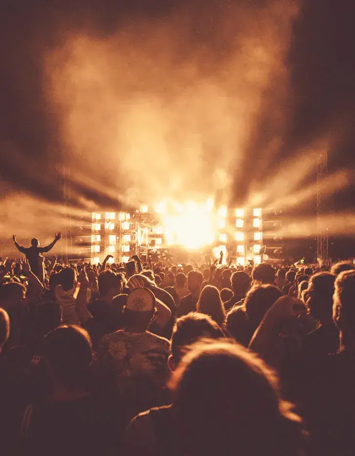 A crowd facing a brightly lit stage at a live event